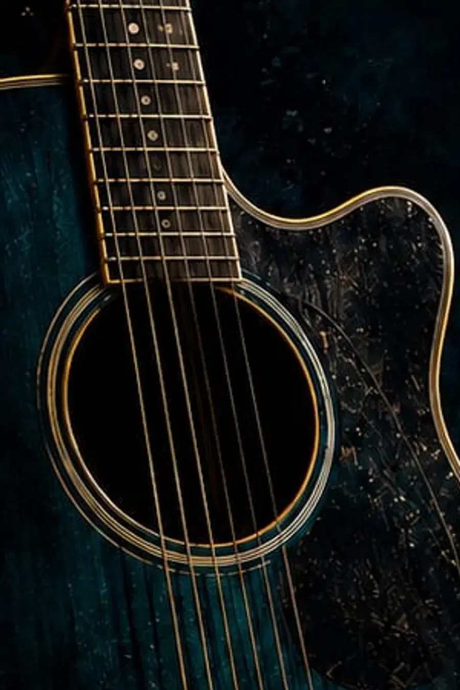 Close-up of an acoustic guitar against a deep teal background